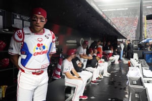 Catcher Tyler Stephenson of the Cincinnati Reds peeks out from the dugout during a rain delay.