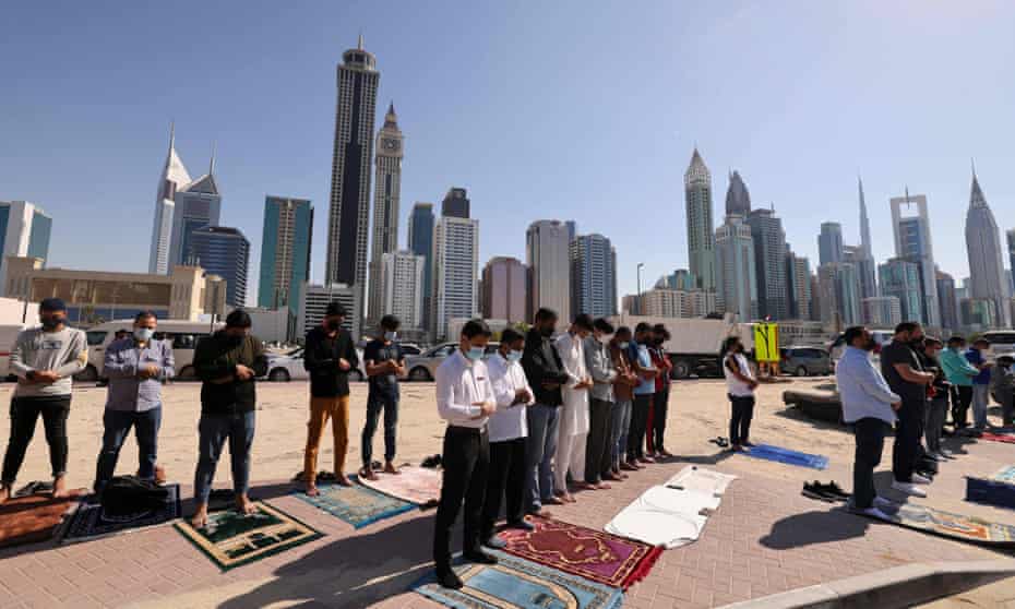 Muslim men perform Friday prayers in an area close to their workplace on the first working Friday in Dubai