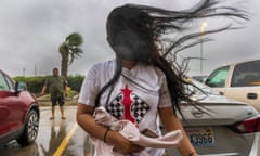 a woman's hair is blown by the wind in a parking lot