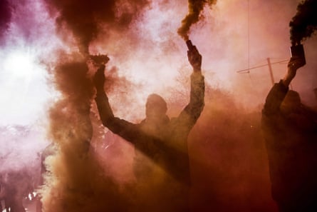 Demonstrators hold up flares during a gilets jaunes (yellow vest) protest in Paris against Emmanuel Macron’s government.