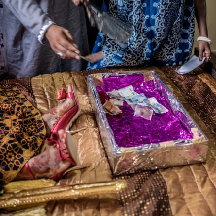 Wedding guests leave money in a box at the foot of the bride’s bed on the morning of her marriage