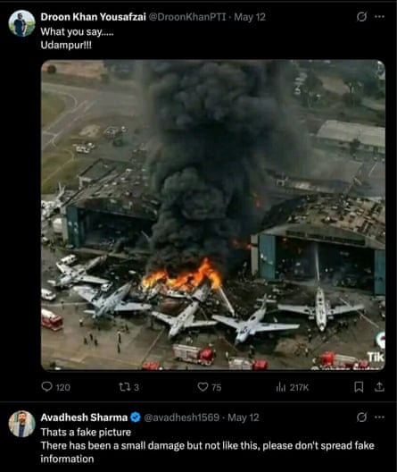 A fake image of burning fighter jets on the ground beside hangars