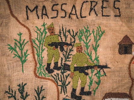 Embroidery of two men with rifles with the word massacres written above them.