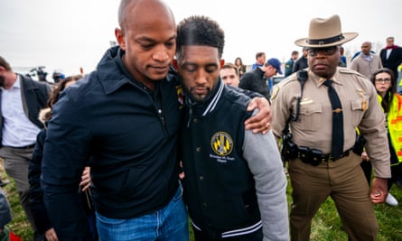 two men with arms around each other outdoors amid a crowd