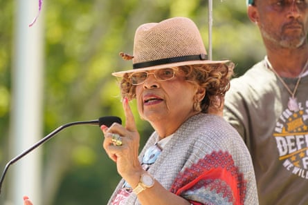 A woman with a fedora speaking into a mic