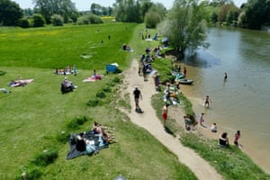Sunbathers and paddlers enjoy the Thames riverbank in the market town of Wallingford in Oxfordshire