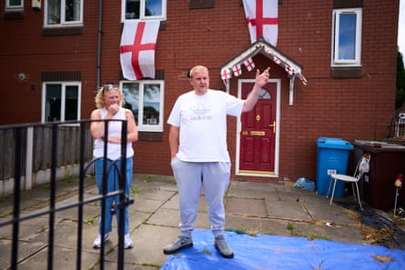 A man and a woman standing outside a house