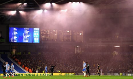 Smoke from flares drifts over the pitch at Brighton v Crystal Palace – but initial reports that away fans had arrived with knives and knuckle-dusters have since been withdrawn.