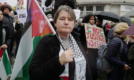 Jacquie Woods holds a Palestinian flag as she takes part in the Camden protest