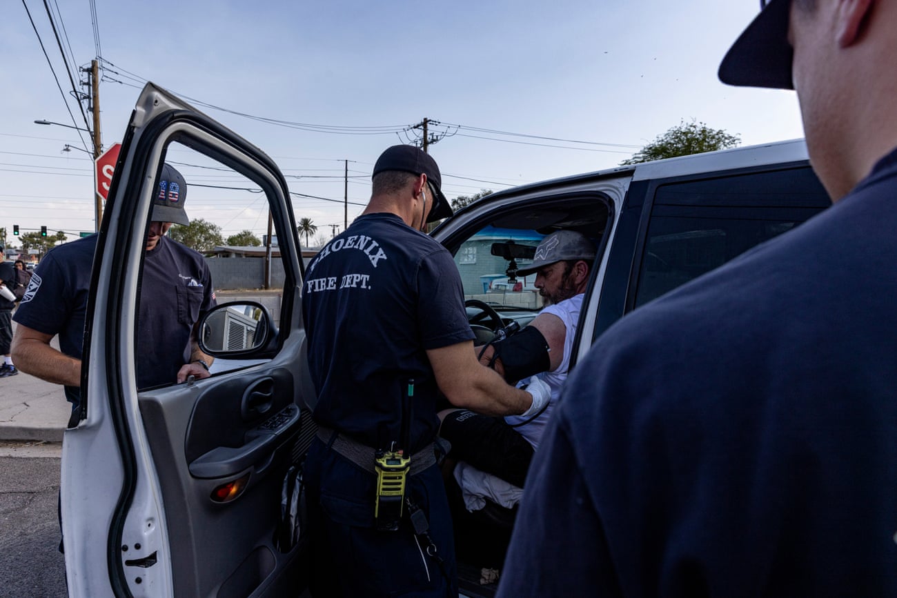 Paramedic checks the blood pressure of a man in his car