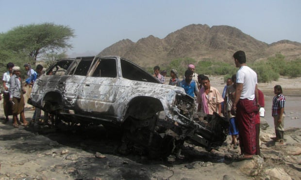 People gather at the site of a drone strike on the road between Yafe and Radfan districts of the southern Yemeni province of Lahj August 11, 2013.