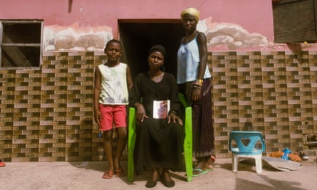 Maimuna Catchura holds the photograph of her late husband with two of couple’s three children outside their home in Bissau.
