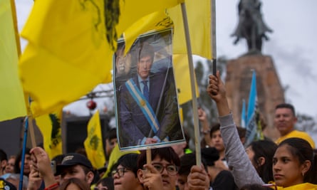 Supporters of Milei hold a poster showing him with the presidential sash during a campaign rally in Salta.