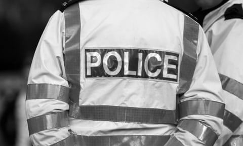 Back view of a police officer in reflective jacket.