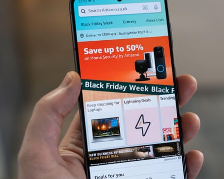 Black Friday Week with big savings advertising banner and page from the Amazon shopping app on a smartphone screen held by a hand