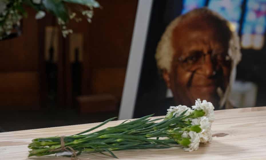 A bunch of carnations atop the pine coffin of Archbishop Desmond Tutu