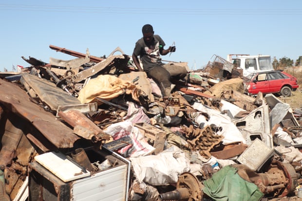 Colin Mapuranga sits on a pile of metal in a scrap yard near Hopley, a settlement outside Harare.