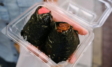 Two nori-wrapped onigiri in a plastic takeaway container