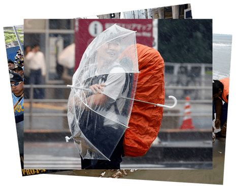 A young man protects himself from heavy rain and wind triggered by Typhoon Dujuan with an umbrella near Shinjuku station in Tokyo