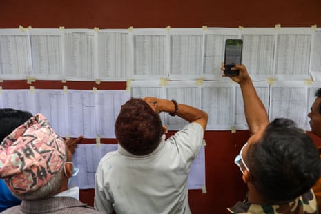People check the list of missing persons pinned on a wall.
