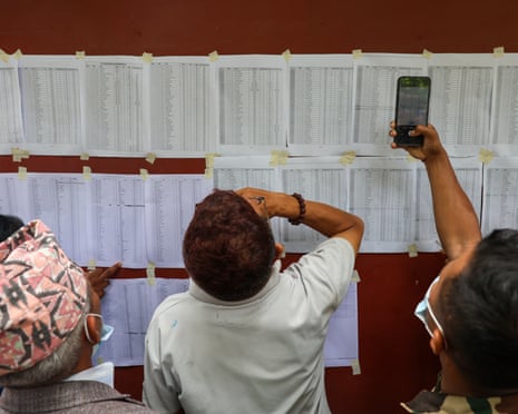 People check the list of those still missing in Nuwakot, Nepal
