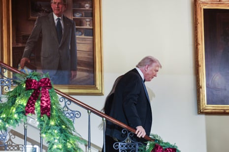 Donald Trump walks down a flight of stairs.