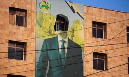 A damaged poster of Syria’s President Bashar al-Assad in Aleppo