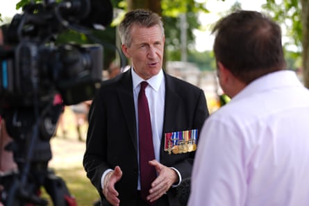 Jarvis, wearing military medals, speaking to the media