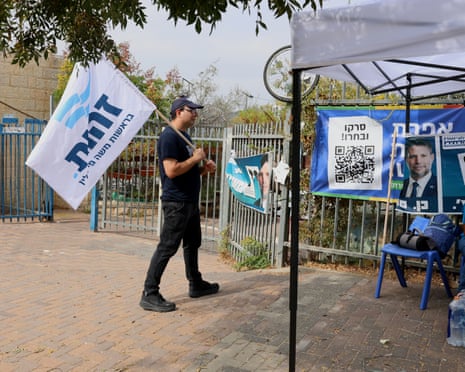 Yitzchak Schwarz carries a flag for the ultra right wing party Zehut, lead by Moshe Feiglin, in a polling station in Efrat.