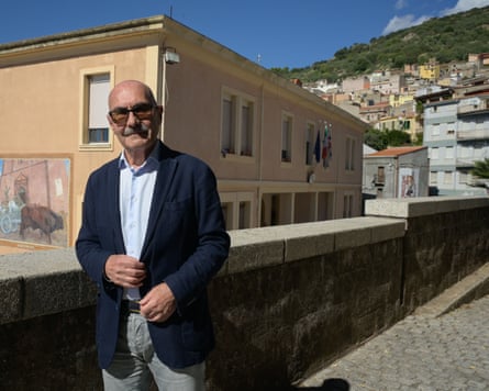 Francesco Manconi leans on a wall with the town behind him.