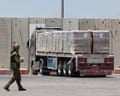 An Israeli soldier walks past an aid truck at a border crossing