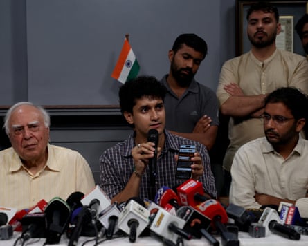 Saurav Das, a spokesperson for the Cockroach movement addresses a press conference in New Delhi on Monday as his co-spokesperson Ashutosh Ranka and Kapil Sibal, an Indian lawmaker, look on.