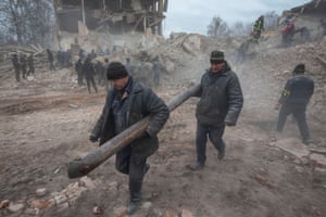 People remove debris at the site of a military base building that, according to the Ukrainian ground forces, was destroyed by an air strike.