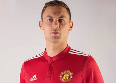 Nemanja Matic poses in a United shirt after signing.