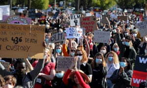 large group of marchers with placards protesting deaths in custody