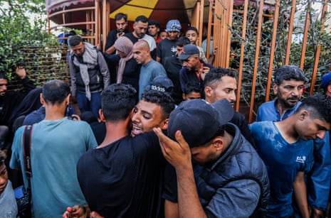 Men mourn for those killed this morning by Israeli fire in the south of the Gaza Strip.