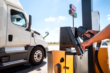 a person pumps gas at a gas station