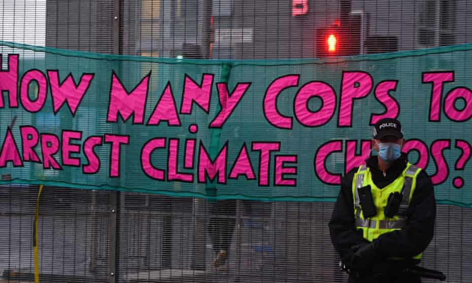 A police officer monitors protesters during a climate change demonstration outside Cop26 in Glasgow