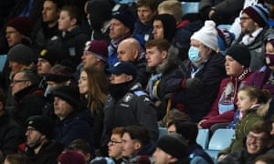 Aficionados en el partido de fútbol de la Premier League inglesa entre Aston Villa y Chelsea el 26 de diciembre.  Uno usa una máscara.