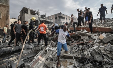 People search the rubble of destroyed buildings in Khan Yunis, Gaza, on Monday
