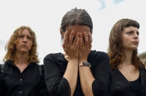 A woman puts her hands to her face