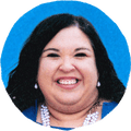 woman with beaded necklace smiles against blue background