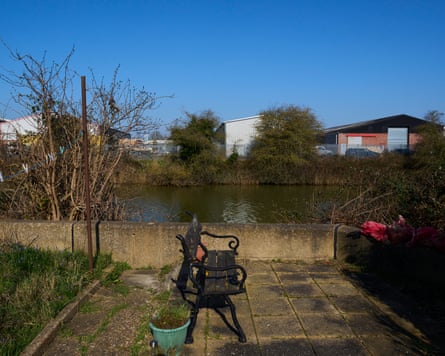 A bench by a river under a blue sky.