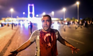 Un hombre cubierto de sangre se coloca cerca del puente del Bósforo como los enfrentamientos militares turcos con los civiles en la entrada del puente en Estambul.