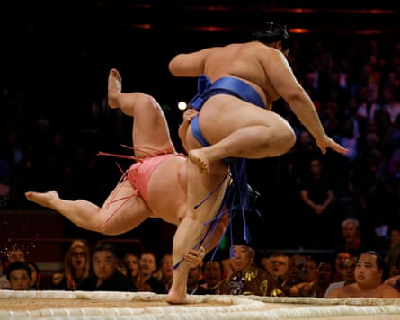 Yokozuna Onosato throws Ura Kazuki out of the ring in the final bout of the night during day one of the five-day Grand Sumo Tournament at the Royal Albert Hall.