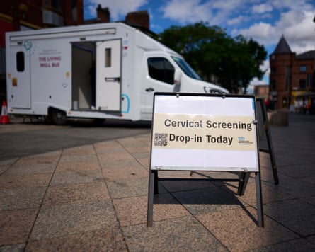 A sign outside the bus reads ‘Cervical screening drop-in today’