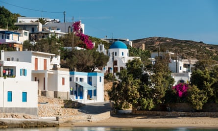 White houses with coloured shutters, a domed church and bit of sandy beach.