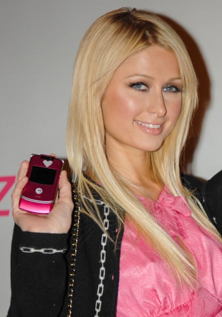 Paris Hilton holds up a pink flip phone