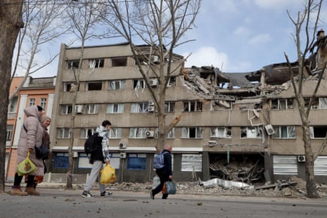 People walk past a damaged building in the Ukrainian city of Mykolaiv.