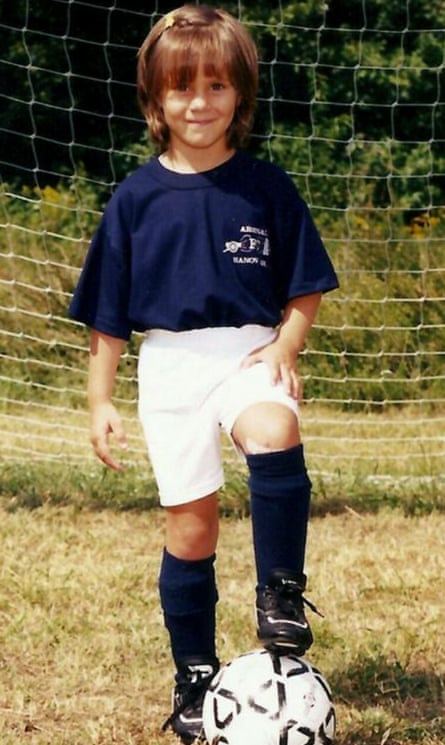 A young Ashley Riefner with a football at her feet.